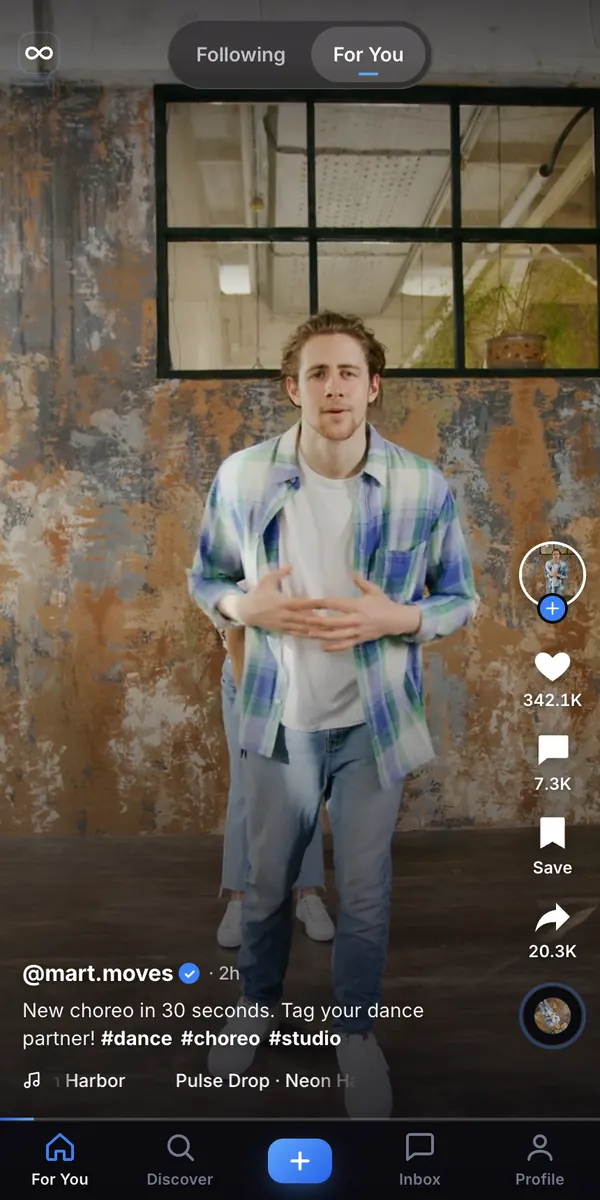 Looply on a phone: a full-screen vertical video with the creator name, caption, hashtags and a bottom tab bar with For You, Discover, Create, Inbox and Profile